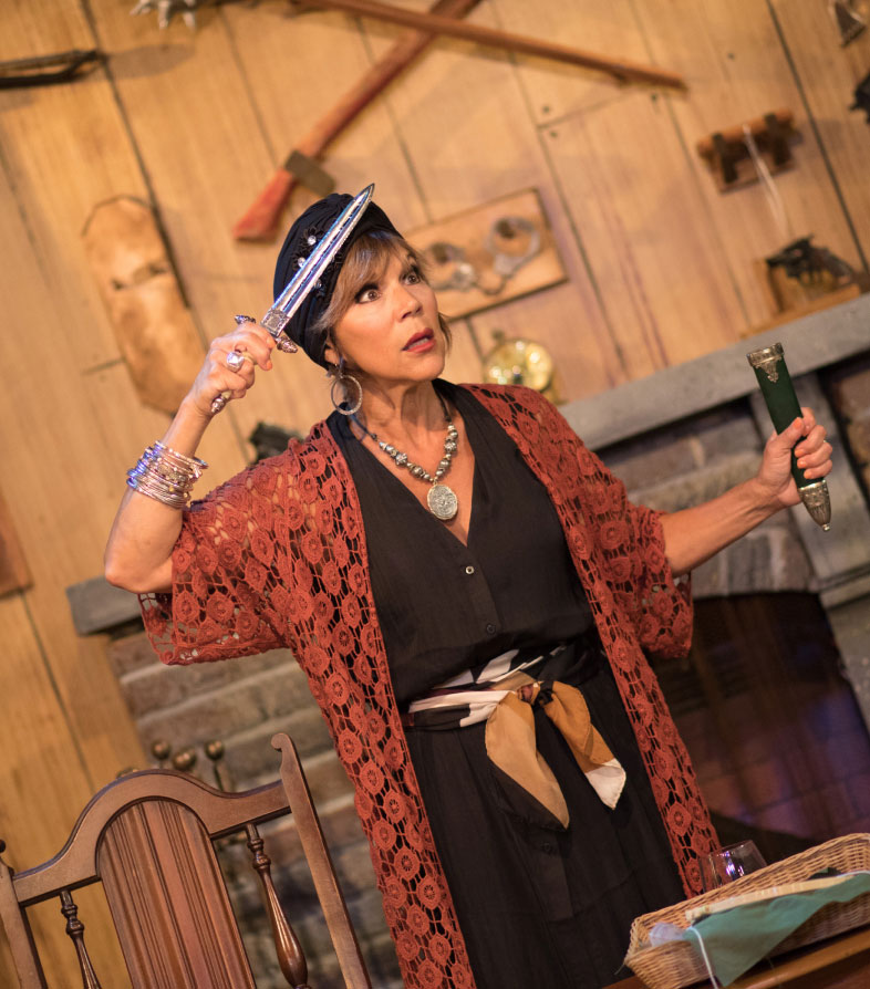 Woman holding dagger dramatically onstage